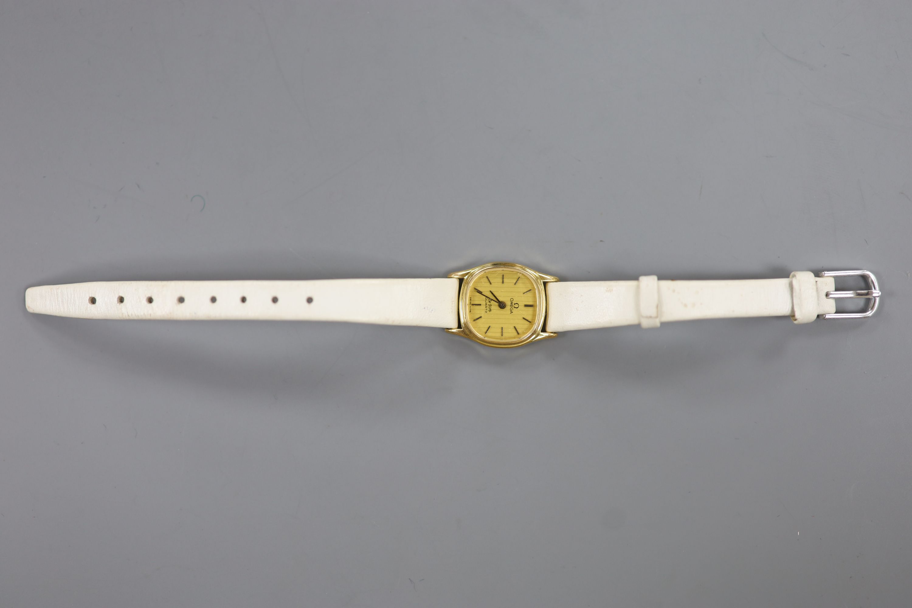 A lady's steel and gold plated Omega De Ville quartz wrist watch, on an associated leather strap.